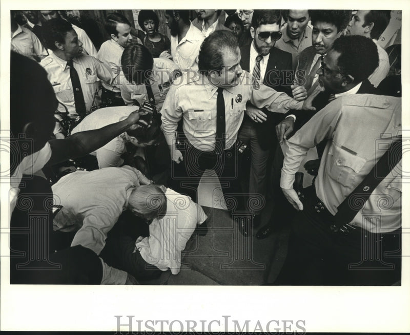 Load image into Gallery viewer, 1984 Press Photo Police officers calm a crowd while arresting Pat Bryant
