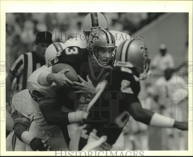 Load image into Gallery viewer, 1989 Press Photo Saints Footballer Bobby Hebert Sacked by Bucs' Winston Moss
