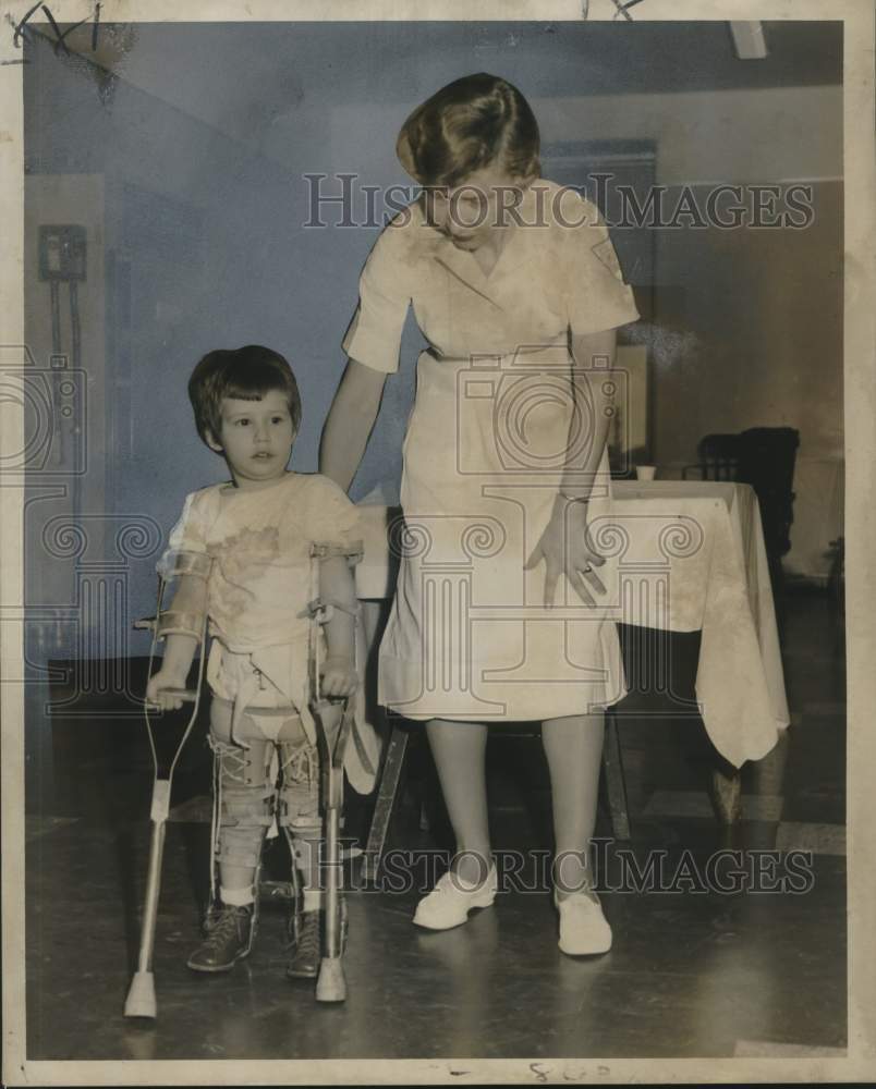 1958 Press Photo Debra Trahan is assisted in walking by Miss Isadore Brown