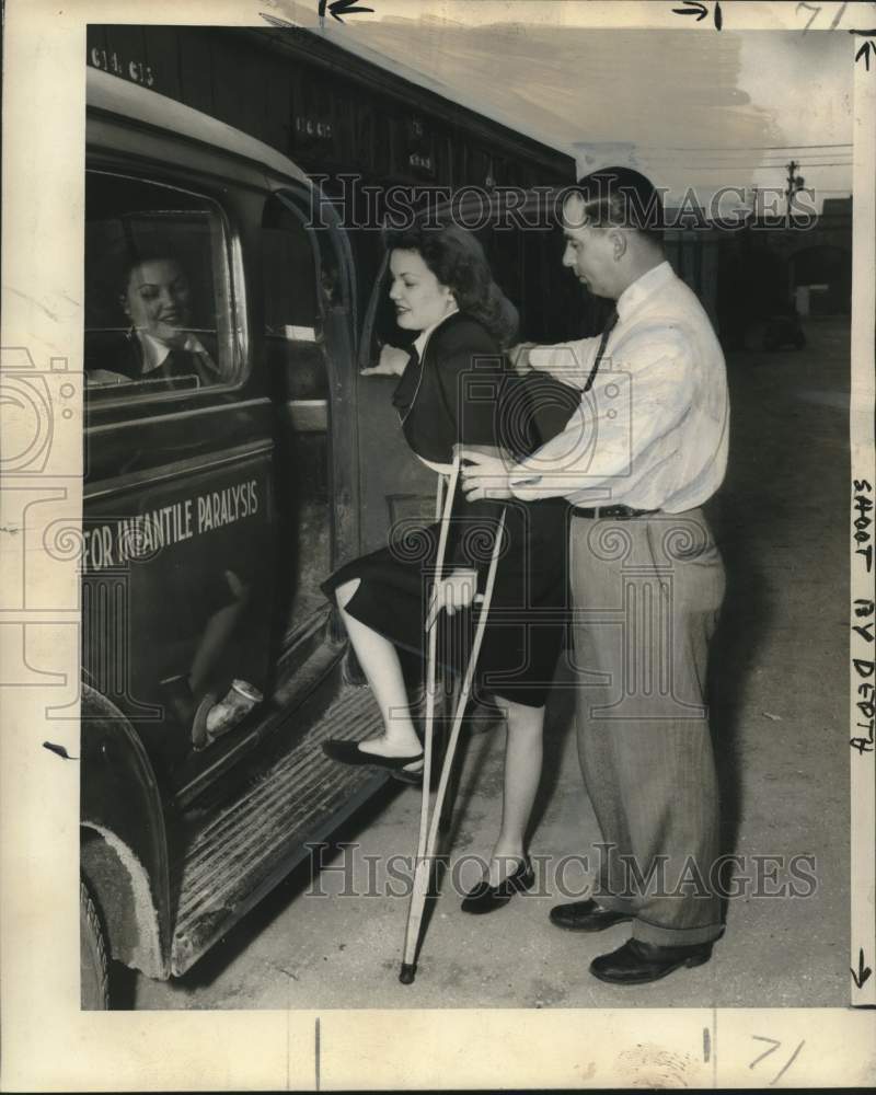 Load image into Gallery viewer, 1948 Press Photo Muriel Miller, Polio victim, helped by Driver Mark Duplantis
