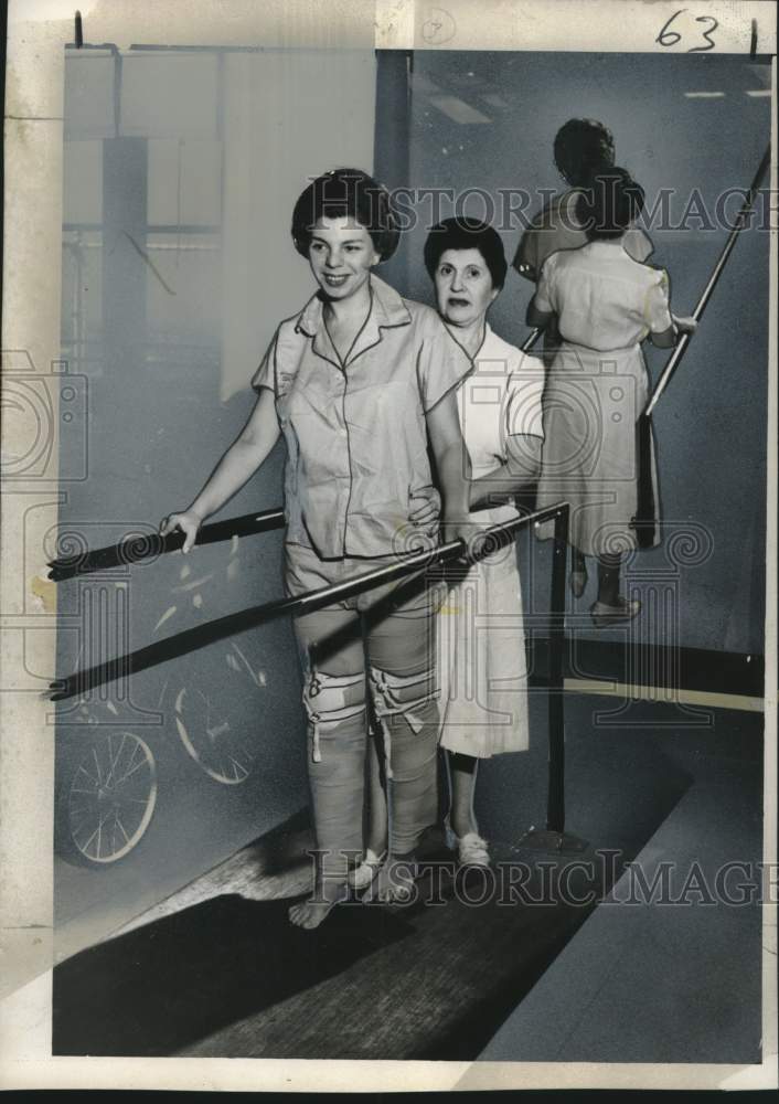 1955 Press Photo Polio Victim learning to walk again with assistance from woman