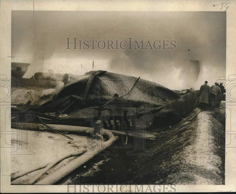 Load image into Gallery viewer, 1957 Press Photo Collapsed storage tanks, firemen and oil workers after fire
