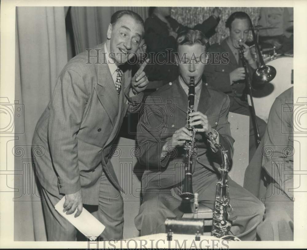 1945 Press Photo Actor Jack Kirkwood admires an Army band as they perform