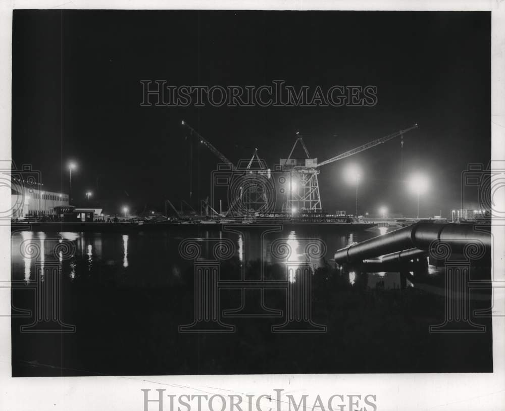 1957 Press Photo Cranes set steel pipes for a new oil rig over Industrial Canal