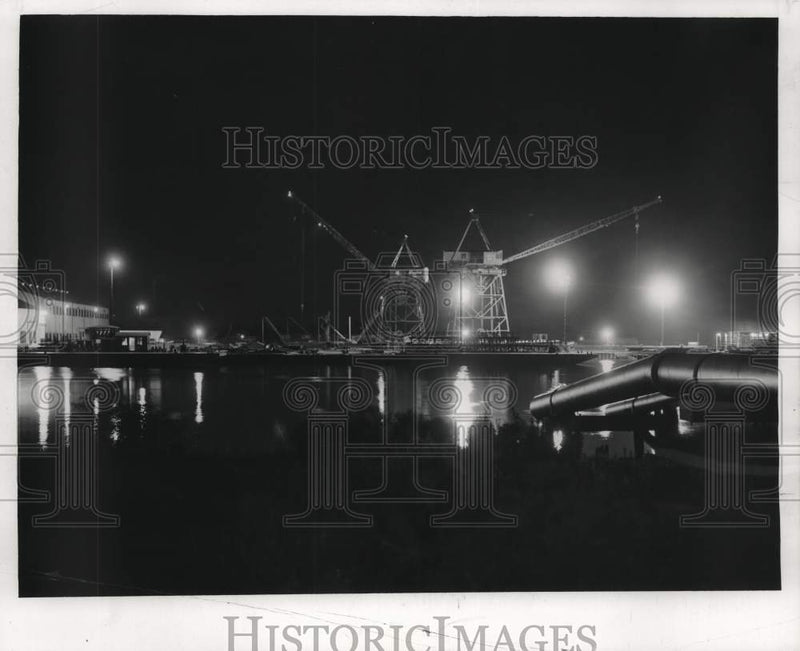 Load image into Gallery viewer, 1957 Press Photo Cranes set steel pipes for a new oil rig over Industrial Canal
