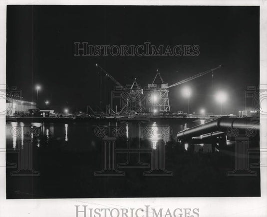 1957 Press Photo Cranes set steel pipes for a new oil rig over Industrial Canal