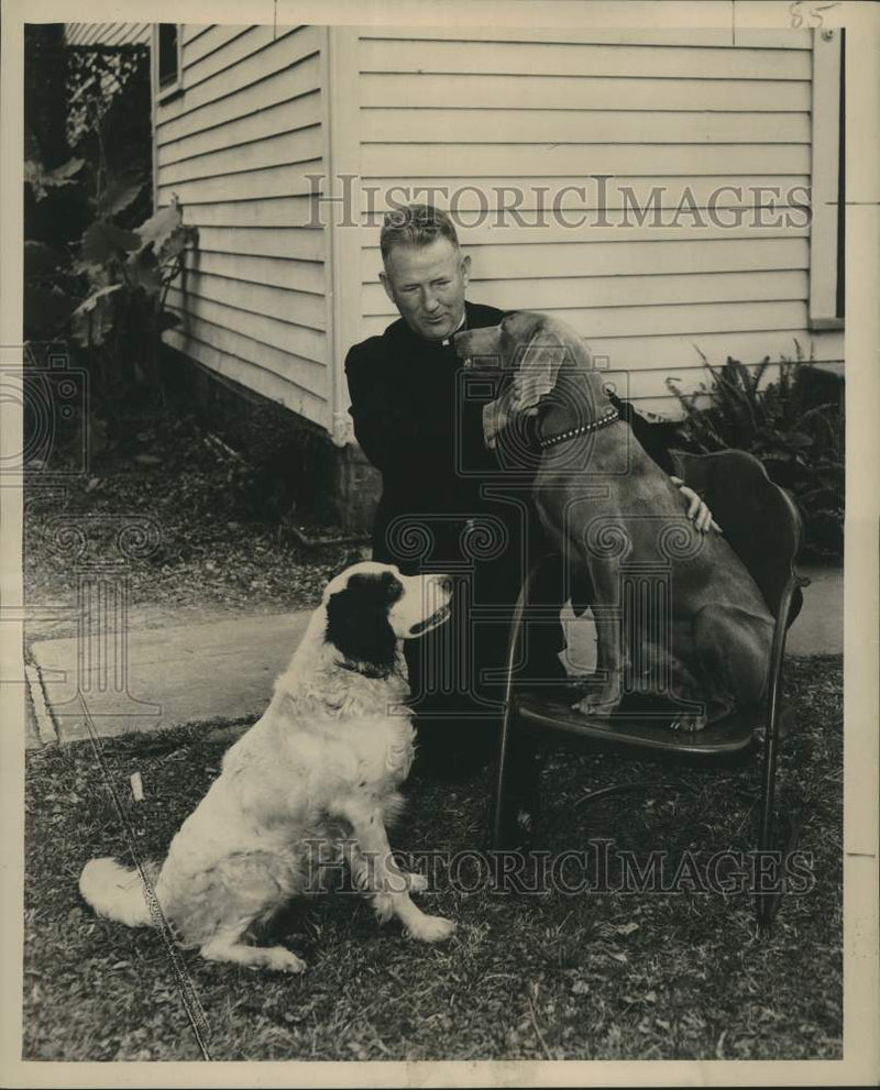 Load image into Gallery viewer, 1954 Press Photo Reverand Thomas J. Maher with his dogs Duke and Beau.

