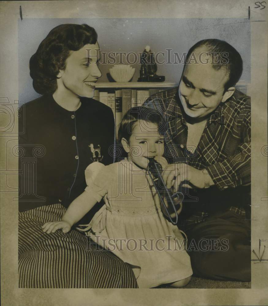 1955 Press Photo Mr. and Mrs. Ned Meredith and Carol, playing a tiny trombone.- Historic Images