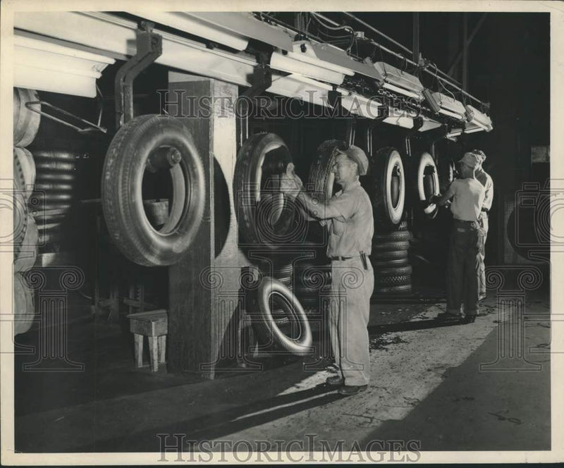 Load image into Gallery viewer, 1951 Press Photo Armstrong Tire &amp; Rubber employee scraping off rubber tips.
