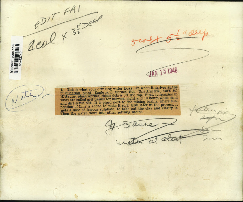 1948 Press Photo N. Saune is skimming debris off top of water coming into plant.