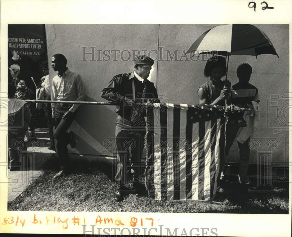 1983 Press Photo Walter Sandifer holds a flag at a Martin Luther King Jr. parade- Historic Images