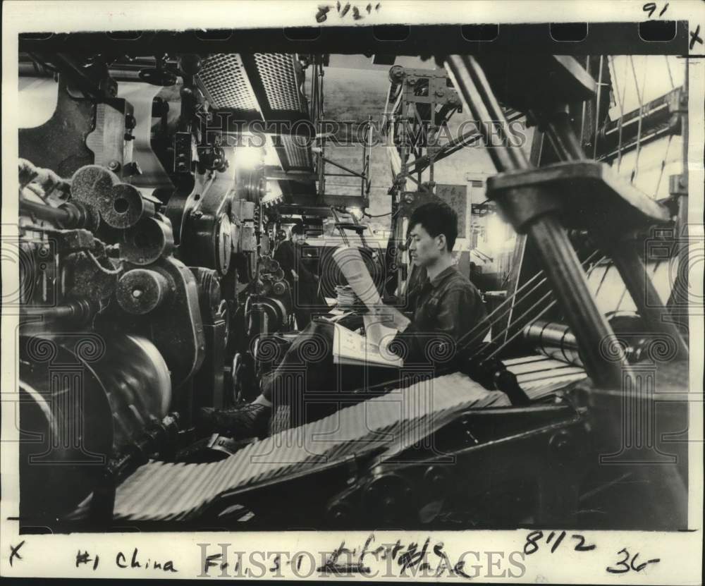 1978 Press Photo Worker checks a copy of People's Daily in China - nox44448
