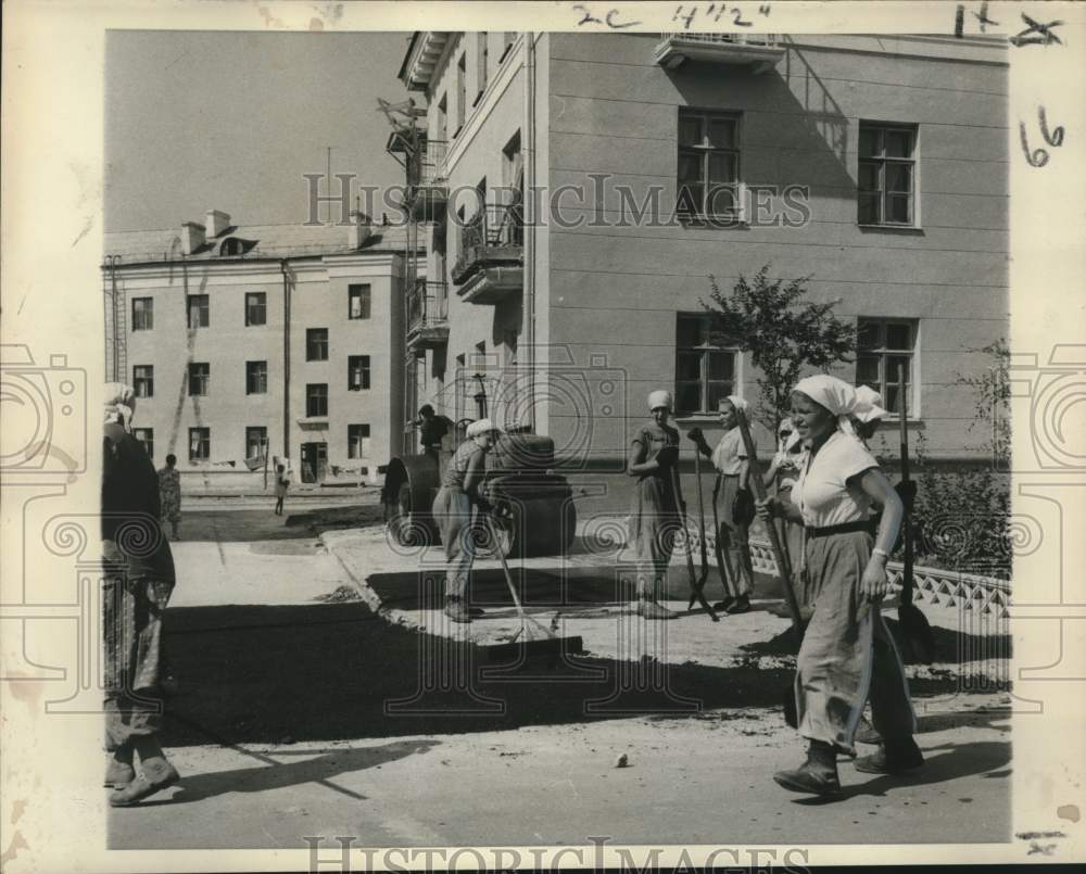 1958 Press Photo Russian women do street hand work, a man drives power roller