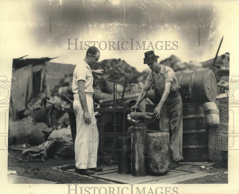 Press Photo Bienville employee Ivan Siegel weighs scrap metal for Harvey Wheat- Historic Images