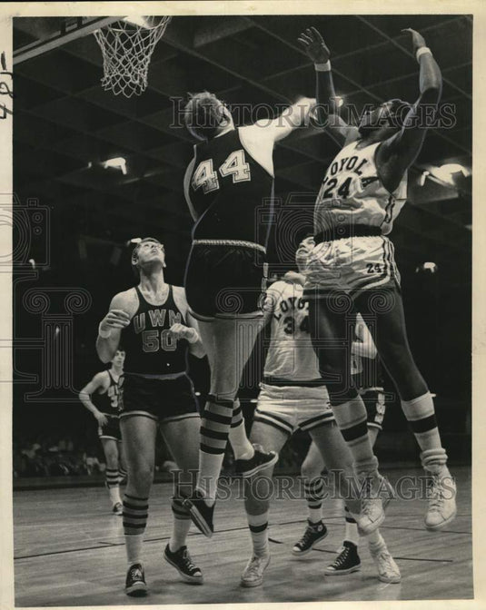 1968 Press Photo Loyola's Ernie Stover, #24 takes a shot over the hand of #44.