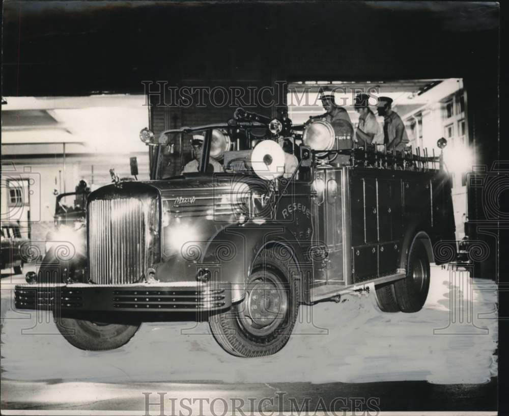 Press Photo Gleaming Fire Department Rescue Truck with firemen aboard.- Historic Images