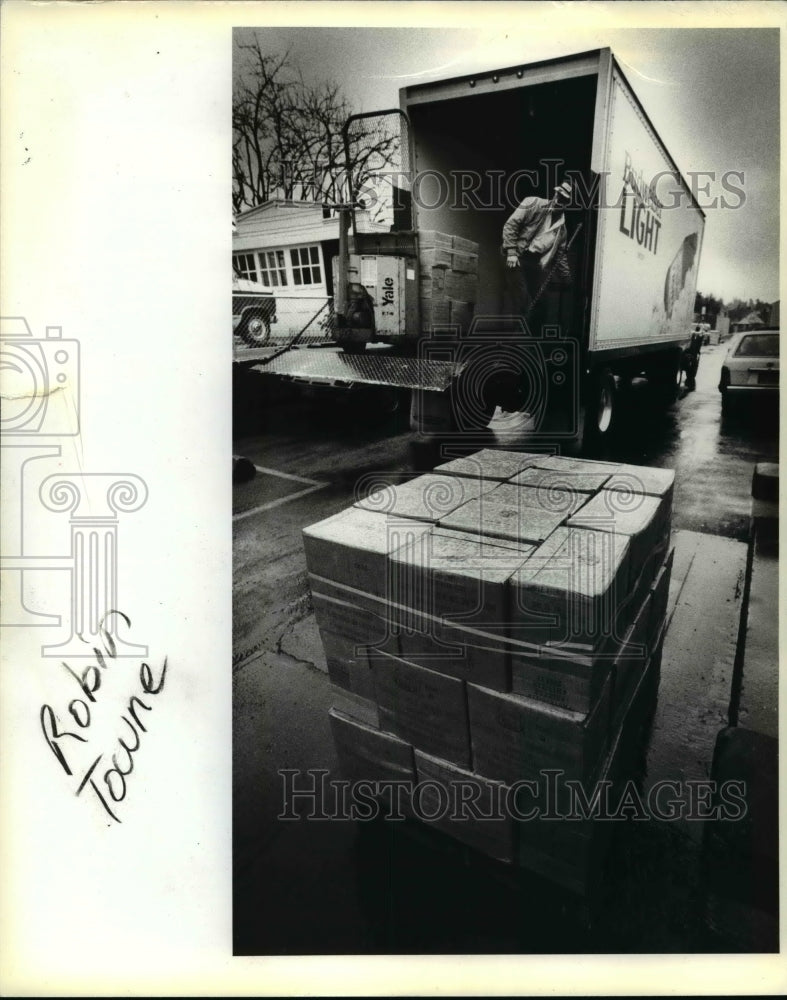 1983 Press Photo Man unloading boxes of surplus food from Columbia Distributing- Historic Images