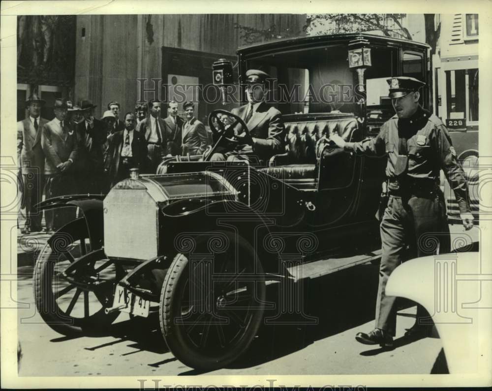 1941 Press Photo Old car driven by chauffeur, men watching in background- Historic Images