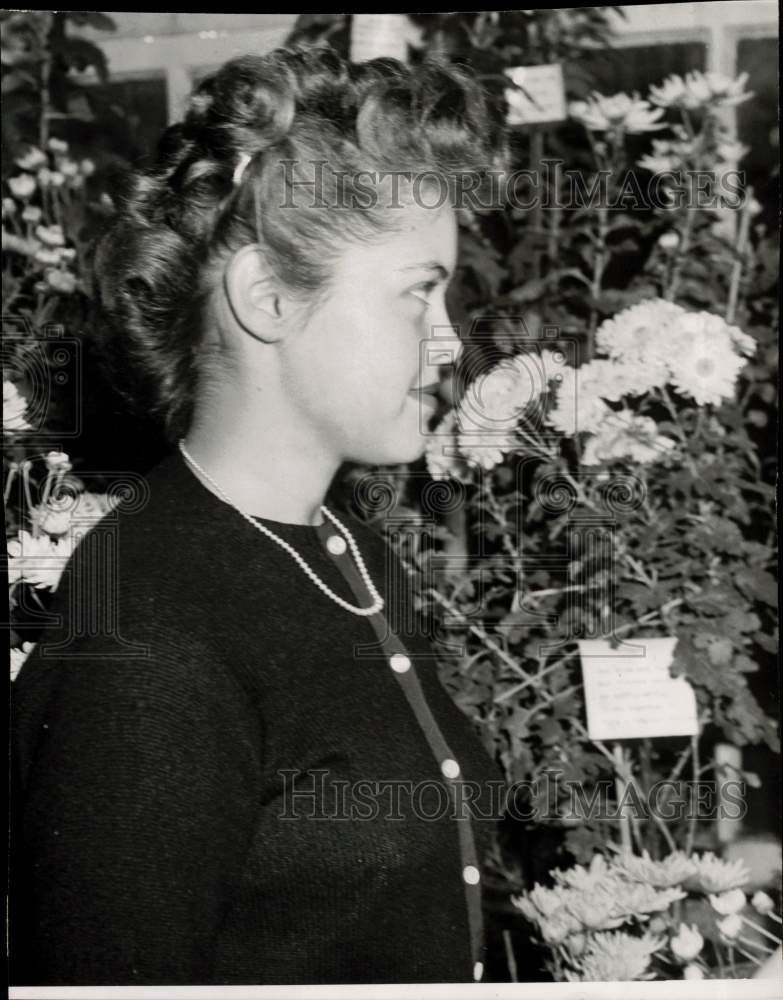 1947 Press Photo Jane Isaacson admiring chrysanthemums at Wellesley College, MA- Historic Images