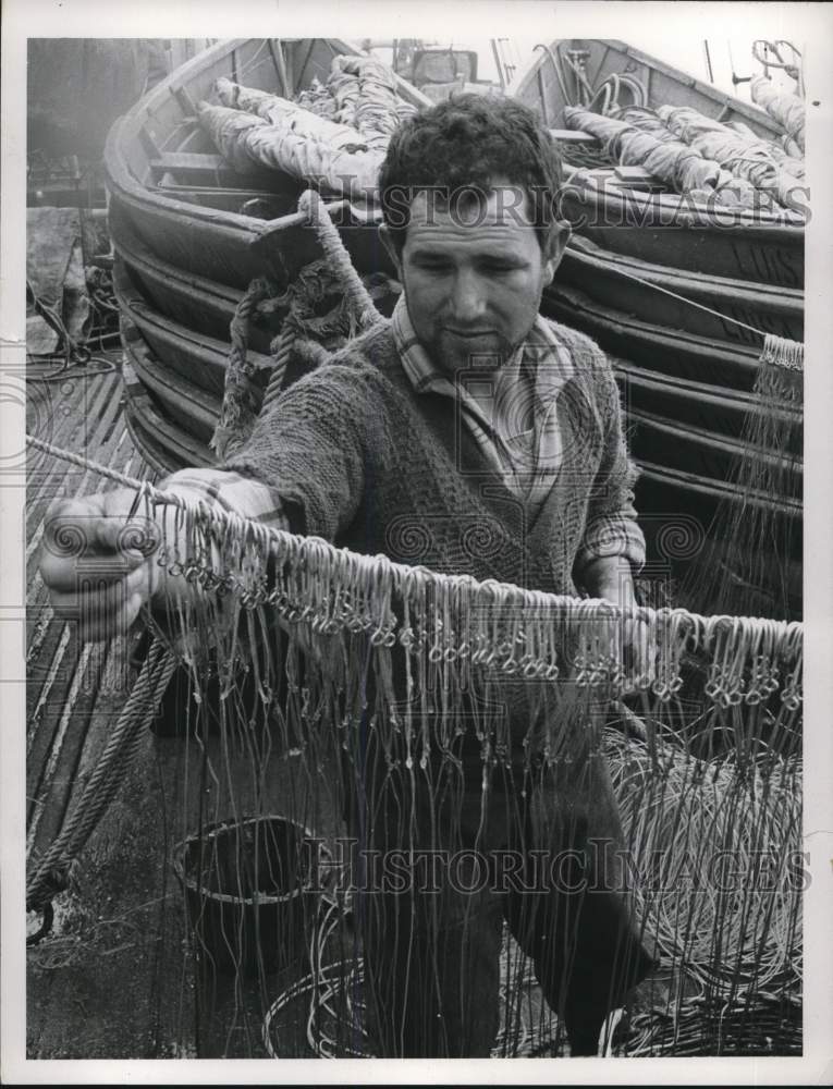 Load image into Gallery viewer, 1960 Press Photo Fisherman hangs fishing lines on rope - pia09975
