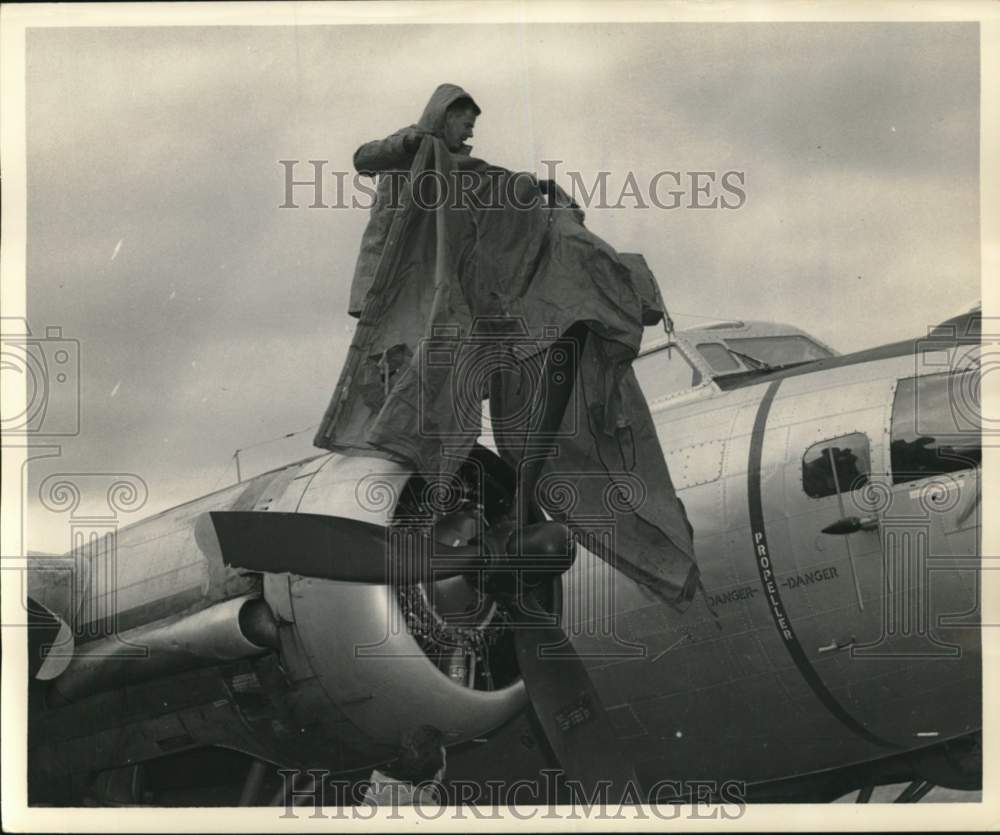 1949 Press Photo Coast Guard covers engine of plane, Greenland - pim00588- Historic Images