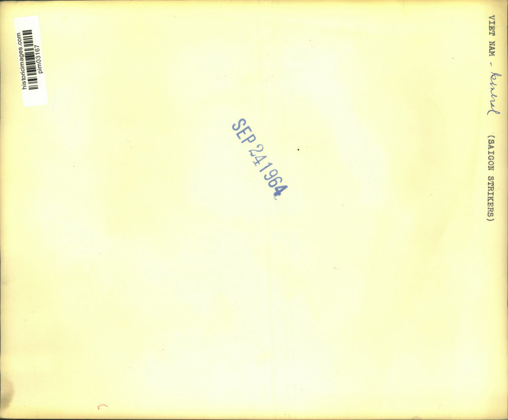 1964 Press Photo Food peddler walks past striking Vietnamese workers in Saigon