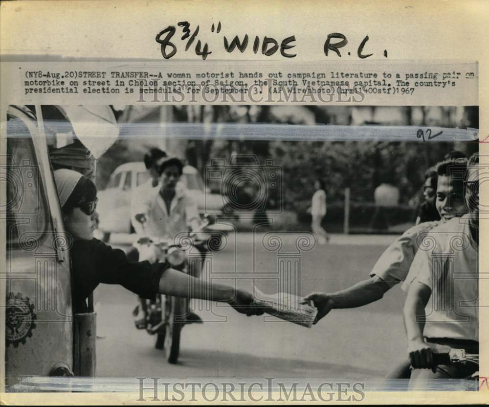 1967 Press Photo Woman hands out campaign materials, Cholon, Saigon, Vietnam- Historic Images