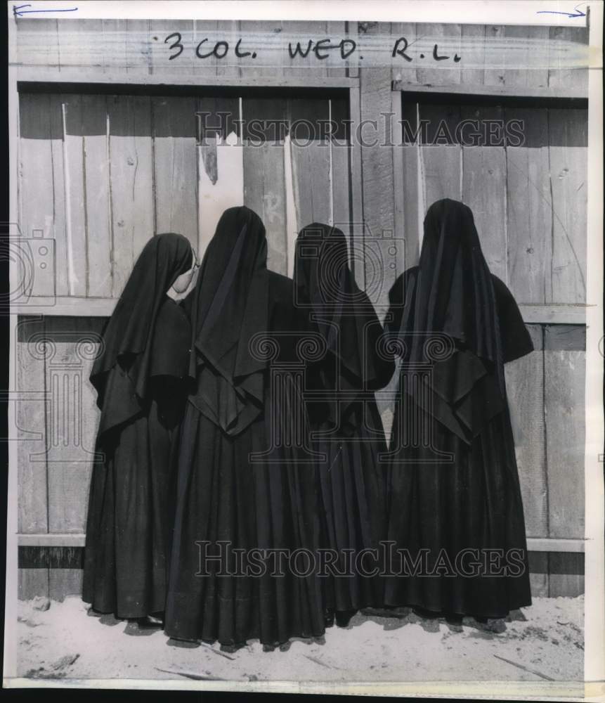 1964 Press Photo Nuns peeking through hole in fence in Vancouver, Canada