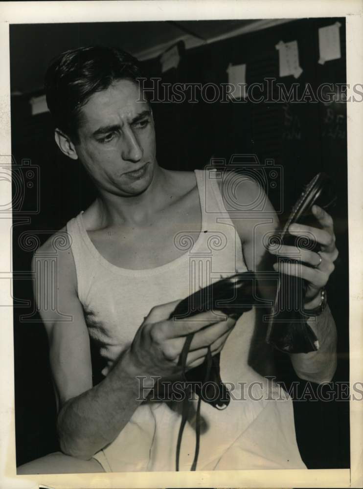 1946 Press Photo Track star Marcel Hansenne checks pair of shoes, New York- Historic Images