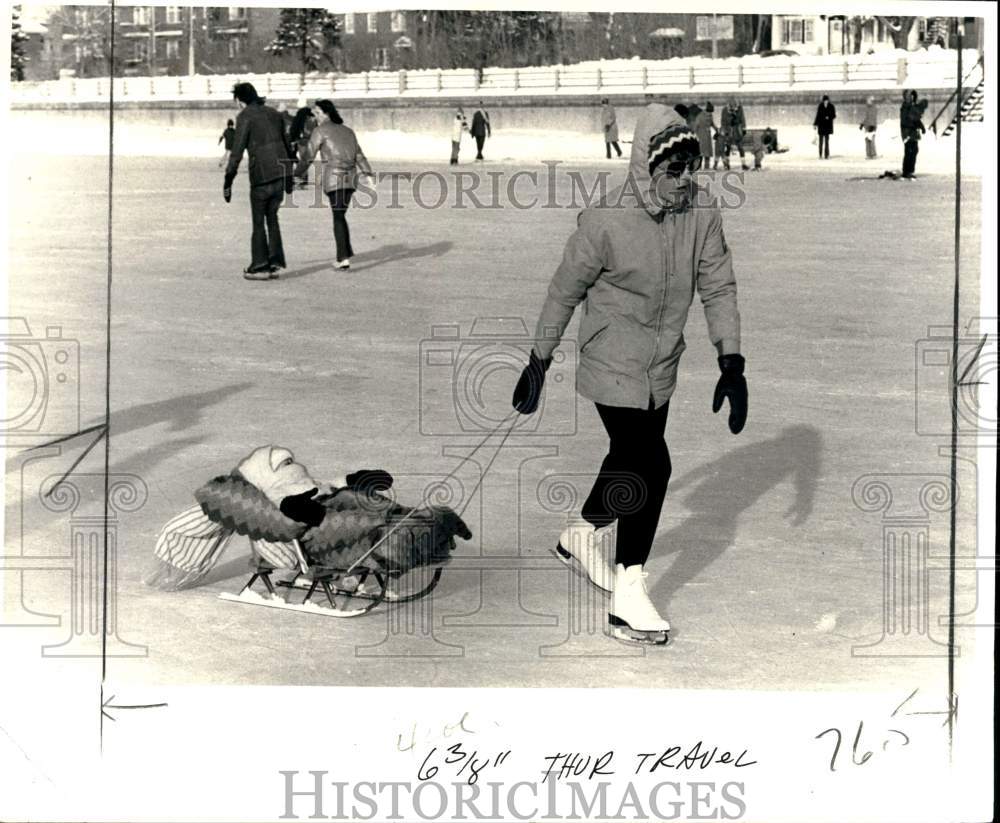 1976 Press Photo Mother with her child on a sled at outdoor skating rink, Canada- Historic Images