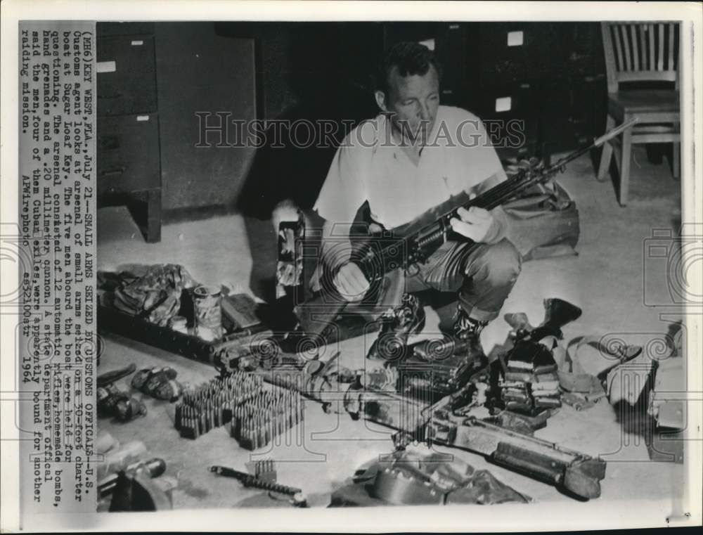 1964 Press Photo US Customs agent with confiscated weapons from boat in Florida