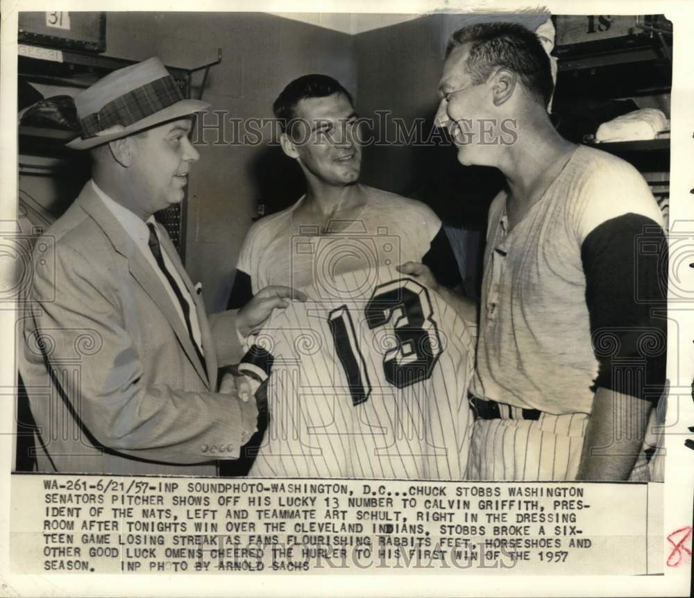 1957 Press Photo Chuck Stobbs shows off his lucky 13 jersey to others, DC- Historic Images