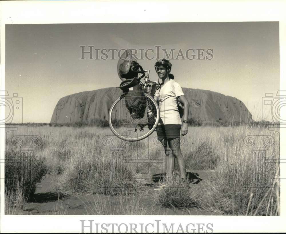 1985 Press Photo Cyclist Jeb Bevers lifts bike near Ayers Rock, Australia- Historic Images
