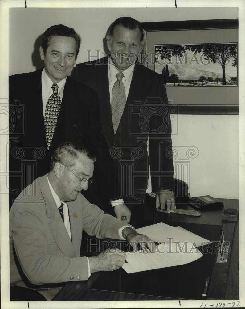 1974 Press Photo H. Randolph Brown signs paperwork with businessmen at desk- Historic Images