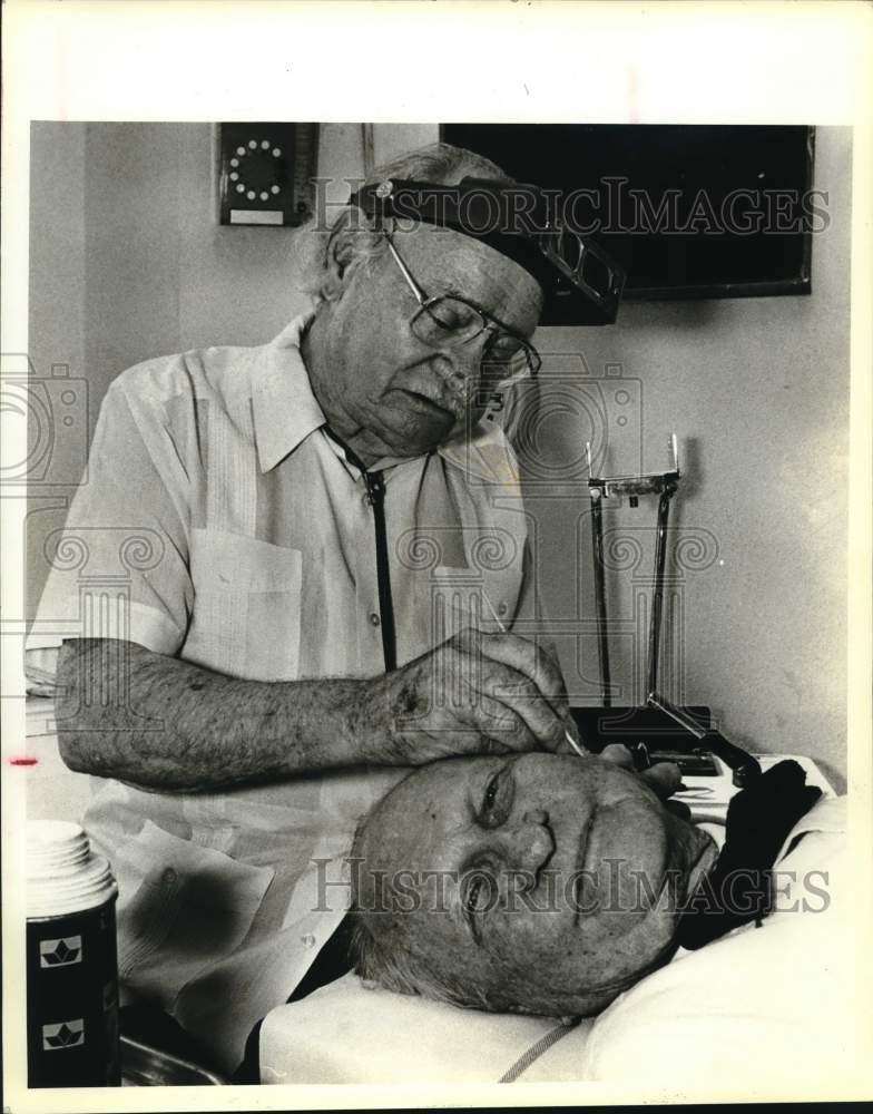 1983 Press Photo Dermatologist Dr. James Pipkin working on patient, Texas