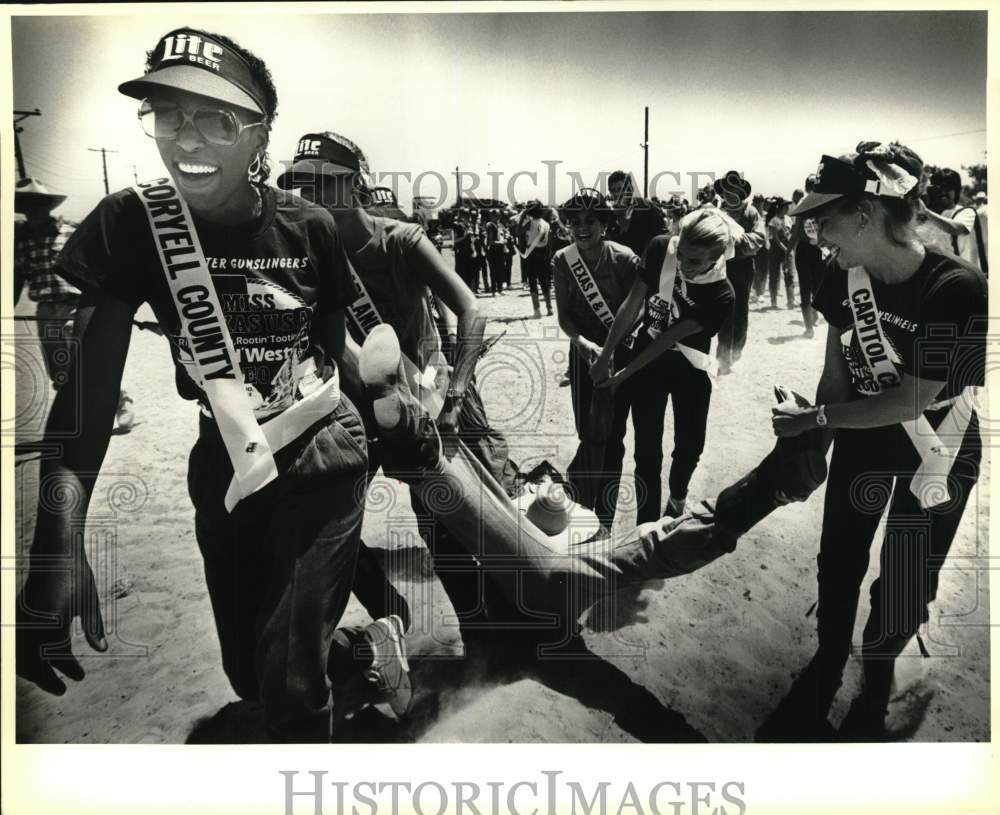 1986 Press Photo Miss Texas USA Rodeo Contestants Drag Rustler From Arena- Historic Images