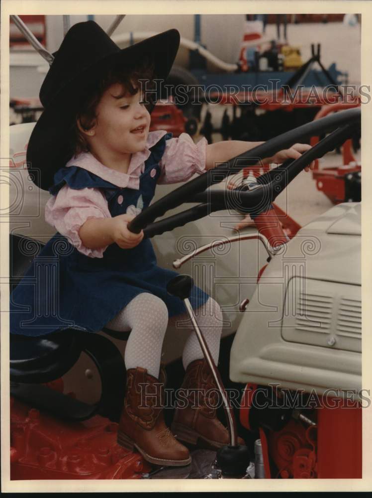 1989 Press Photo Sarah Hernandez, 2, sitting on tractor at the Stock Show, Texas- Historic Images