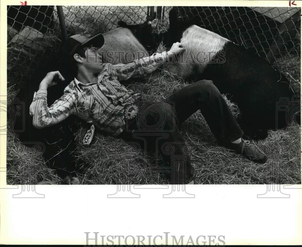 1984 Press Photo Wesley Linder rests with pigs at San Antonio Stock Show &amp; Rodeo- Historic Images