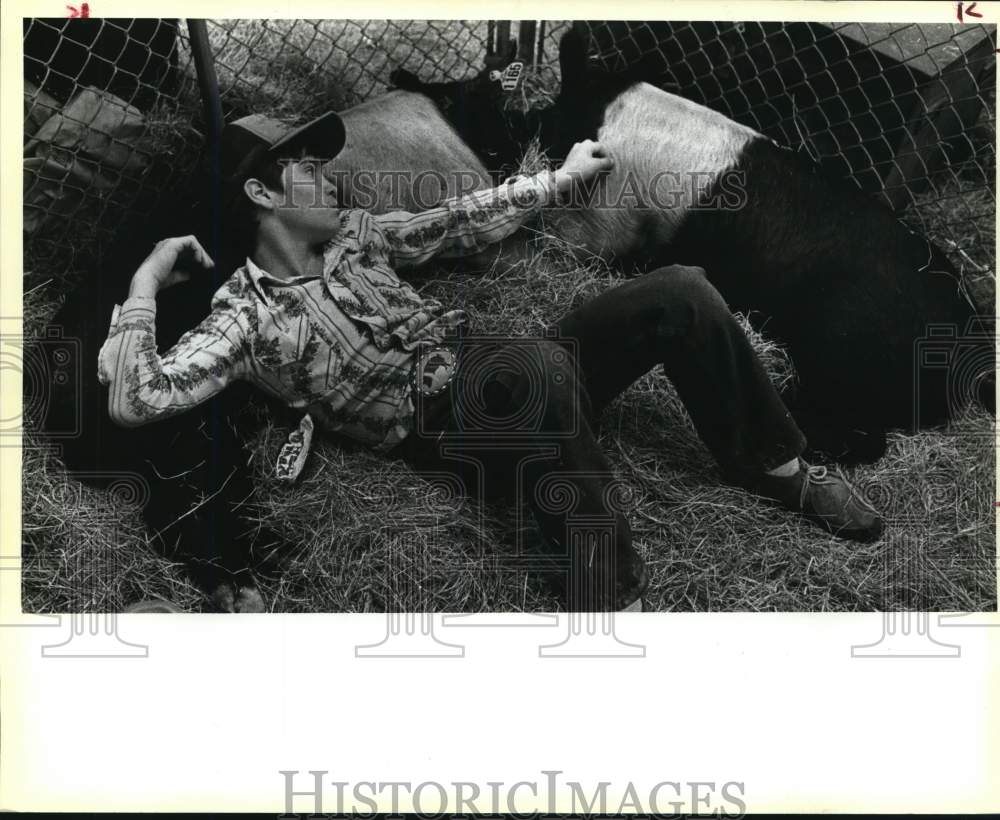 1984 Press Photo Wesley Linder rests with pigs at San Antonio Stock Show & Rodeo- Historic Images