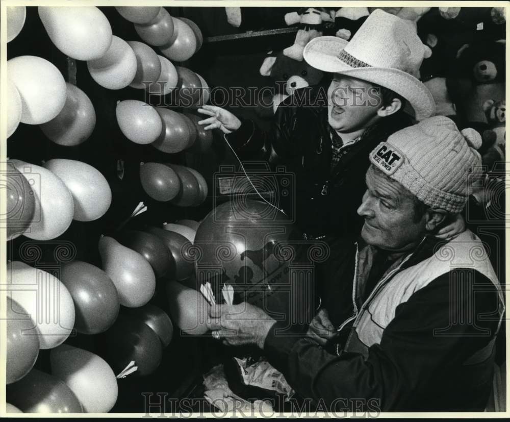 1986 Press Photo Carnival Worker Helps Boy, San Antonio Stock Show & Rodeo- Historic Images