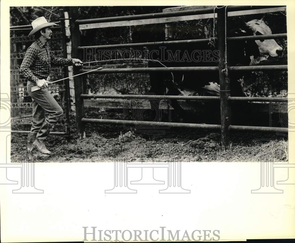 1983 Press Photo Clyde Kimbro prods Bull into Chute for Oldtimers Rodeo- Historic Images