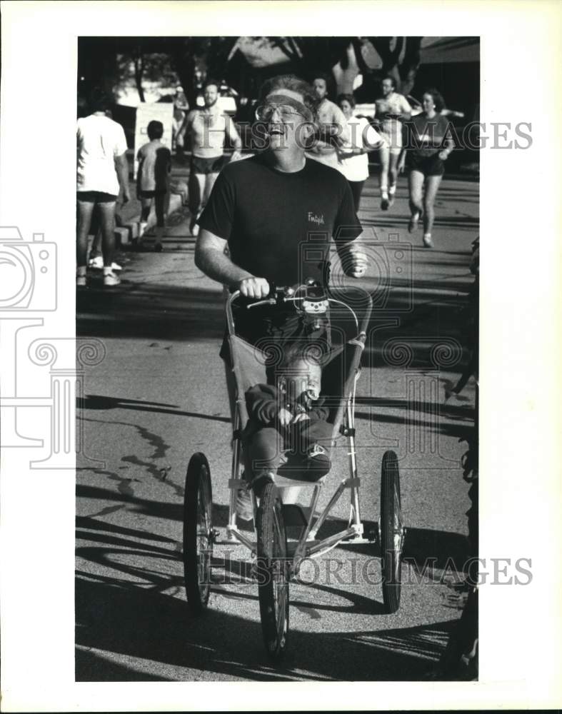 1987 Press Photo Boyce Elliott, III Pushing Stroller at Elf Louise Jingle Jog- Historic Images