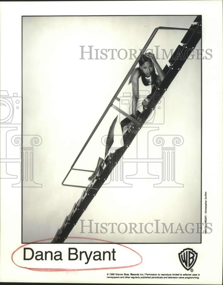 1996 Press Photo Musical Artist Dana Bryant on ladder in portrait - sap08067- Historic Images