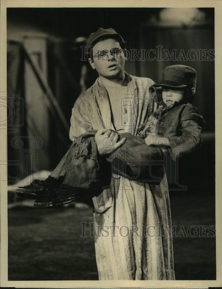 1976 Press Photo Actor Gary Burghoff carries child in &quot;M*A*S*H&quot; scene on CBS TV- Historic Images