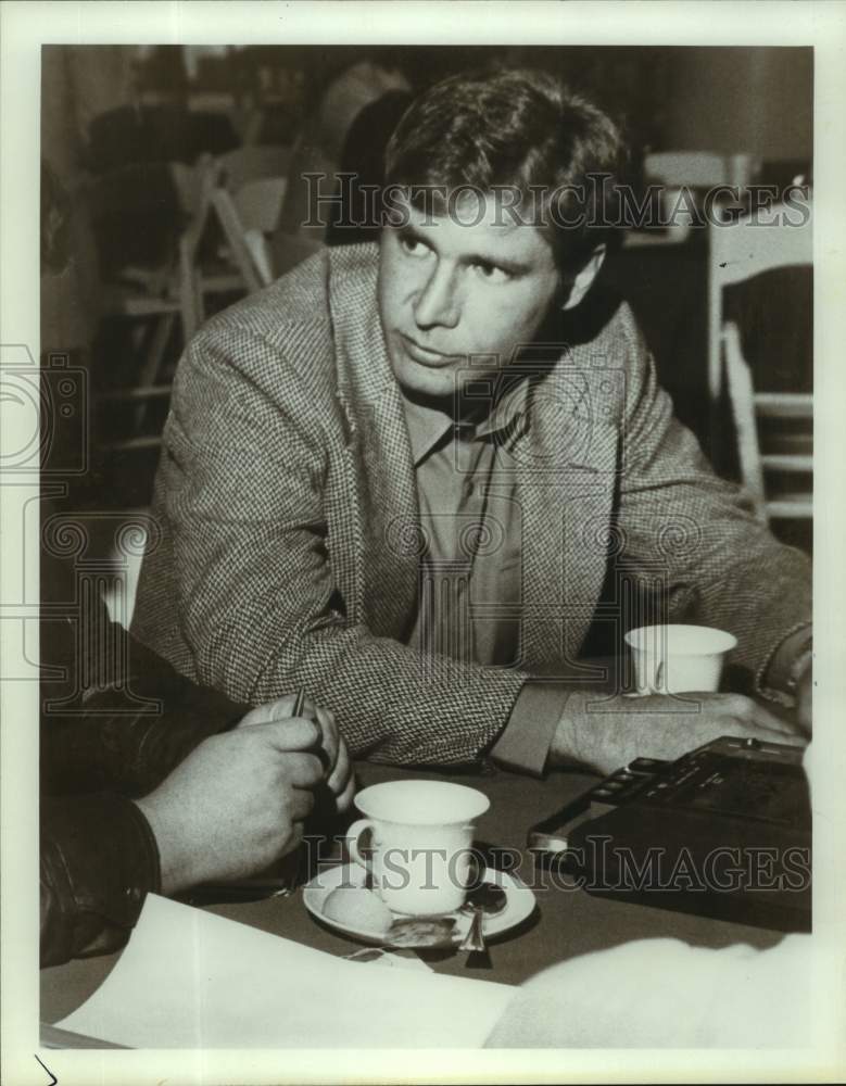 1980 Press Photo Actor Harrison Ford listens while seated at table - sap10842- Historic Images