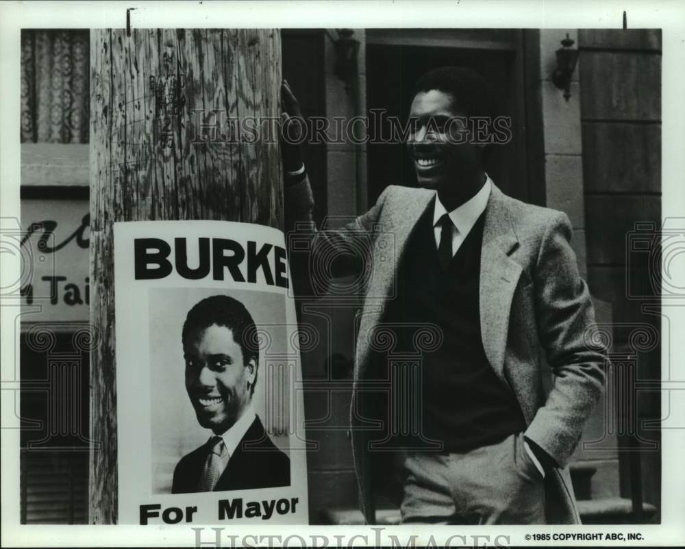 1985 Press Photo Mr. Burke, standing next to &quot;Burke for Mayor&quot; poster- Historic Images