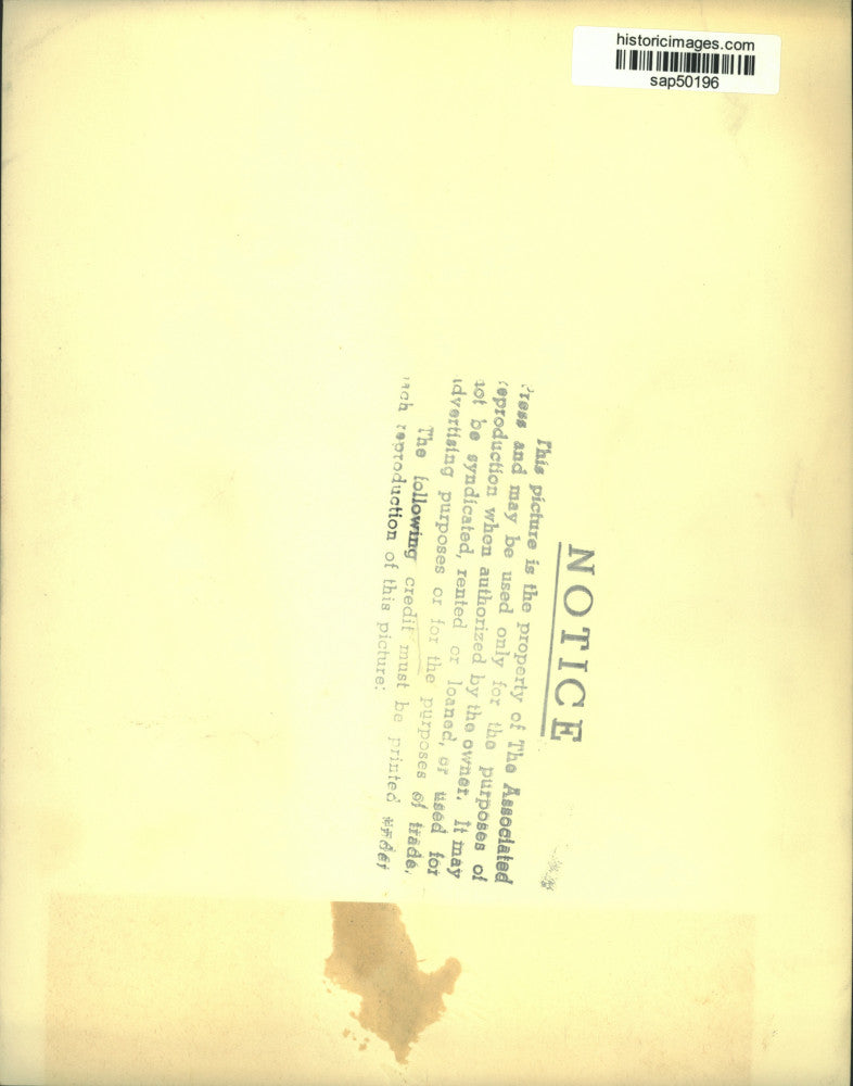 Press Photo Man Sits in Chair, Speaks on Telephone - sap50196
