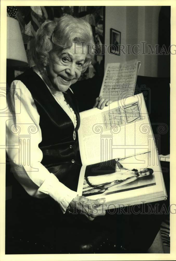 Press Photo Elderly Woman Holds Scrapbook With Photo of Younger Self - sap52964