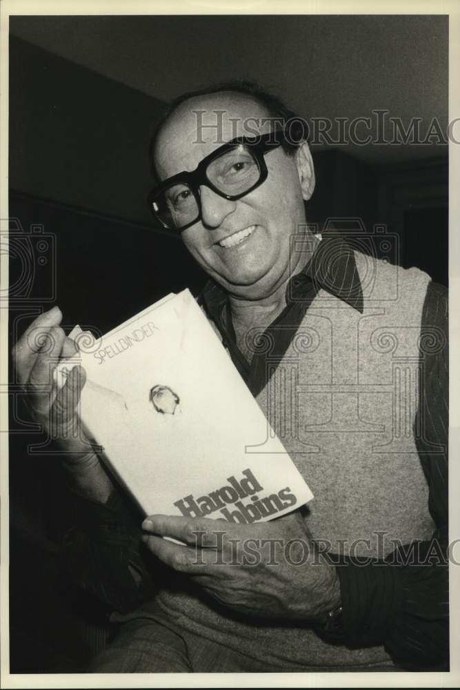 1983 Press Photo Novelist Harold Robbins Holds &quot;Spellbinder&quot; Book in New York- Historic Images