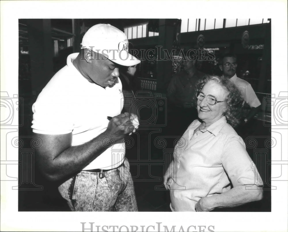 1990 Press Photo Houston Oilers football player William Fuller signs for a fan- Historic Images